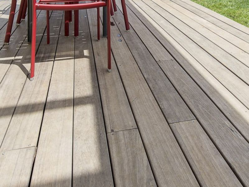 Terrasse en bois installée dans un jardin avec mobilier extérieur